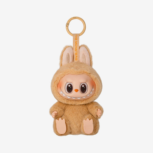 Labubu Baba keychain plush from the "Have a Seat" series, featuring a soft peach furry costume with bunny ears and wide-eyed smile, sitting with legs stretched forward.