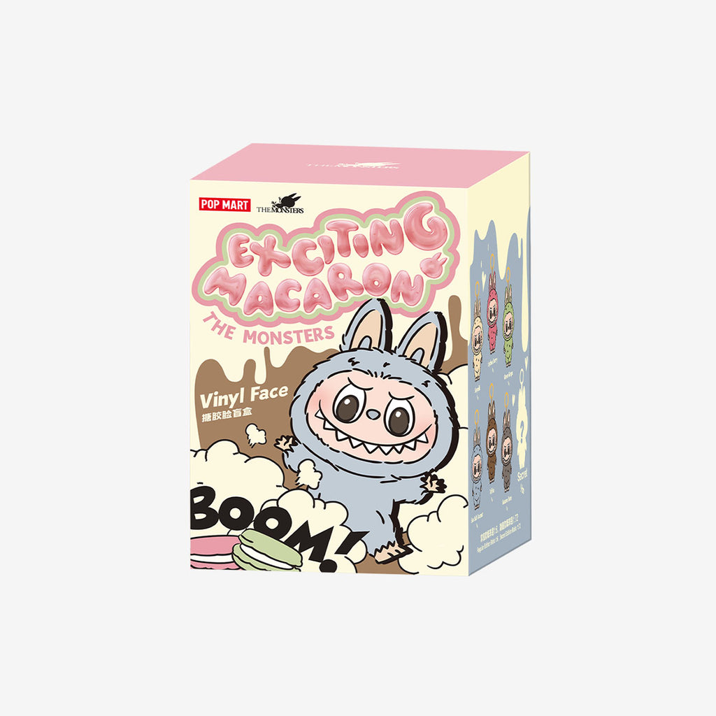 Packaging box of Pop Mart Labubu “Exciting Macaron” series featuring a grey fuzzy Labubu character with bunny ears on the front and a lineup of collectible designs illustrated on the side.