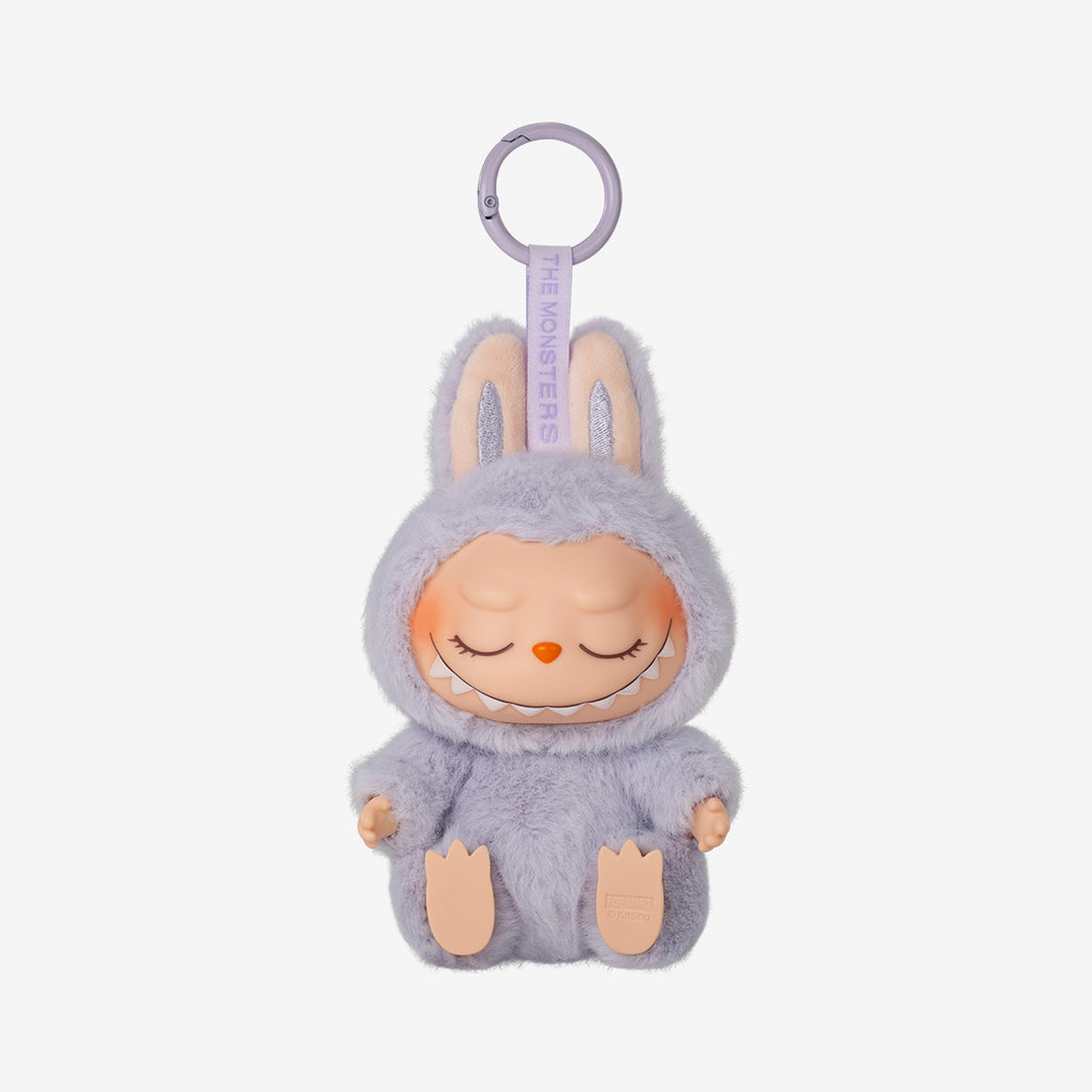Labubu Zizi keychain plush from the "Have a Seat" series, featuring a soft peach furry costume with bunny ears and wide-eyed smile, sitting with legs stretched forward.