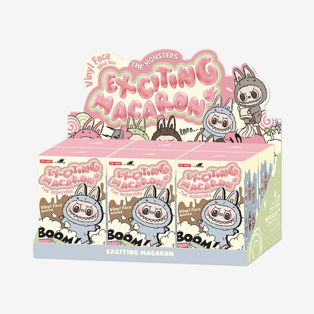Display box of Pop Mart Labubu "Exciting Macaron" vinyl face blind box series, featuring colorful pastel packaging with cartoon illustrations of Labubu characters in bunny suits and playful macaron-inspired designs.