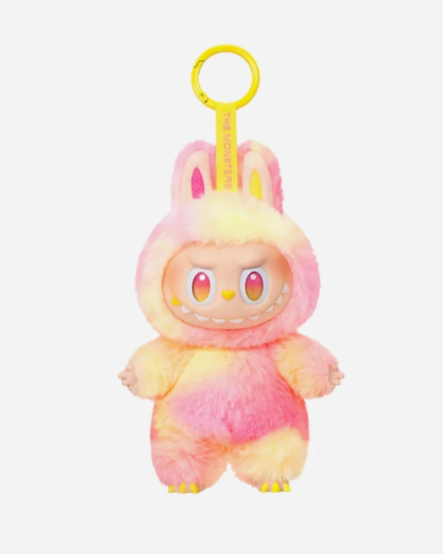 Labubu “Loyalty” plush keychain from the Big Into Energy series, featuring a soft pink-yellow-colored furry bunny suit, playful wide grin with visible teeth, and matching keyring tag.